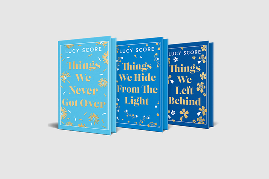 The three books in the Knockemout trilogy, featuring covers in shades of blue with gold flower detailing and sprayed edges.