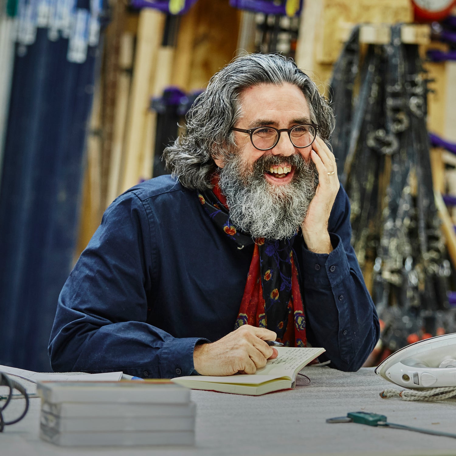 A portrait of David Broom, smiling with a notebook